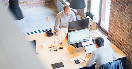 Coworkers on their computers at their desks in an office.