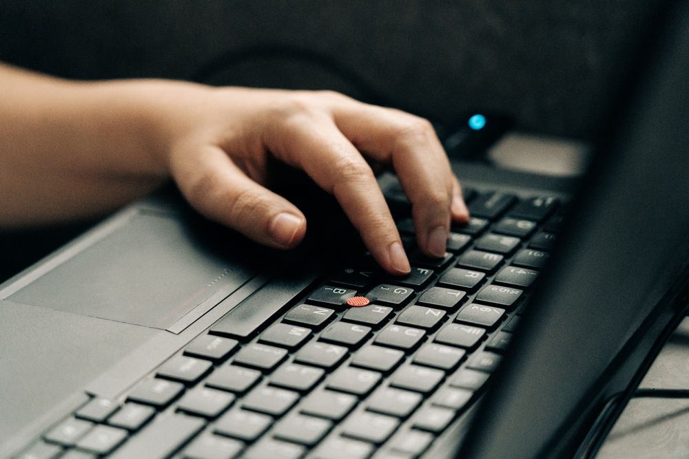 A person using the keyboard on a PC.