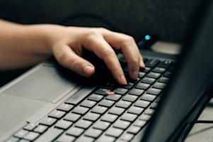 A person using the keyboard on a PC.