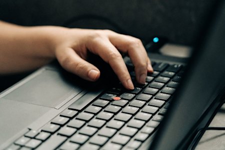 A person using the keyboard on a PC.