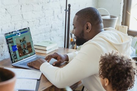 Parent and child working on a laptop at home using Splashtop