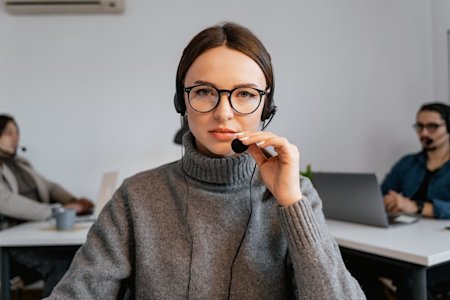 An IT support agent with a headset on in an office.