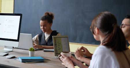 Young woman working on a laptop in a collaborative office space showcasing the ease of Splashtop's remote access