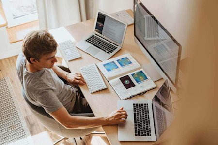 A man at his desk using a remote access program on his laptop