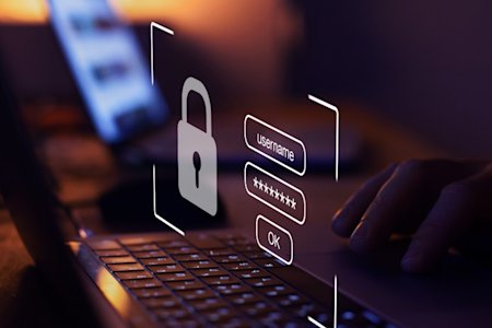 A person typing their login credentials on a keyboard.