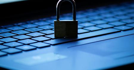 Padlock resting on a laptop keyboard, symbolizing IT data security and protection.