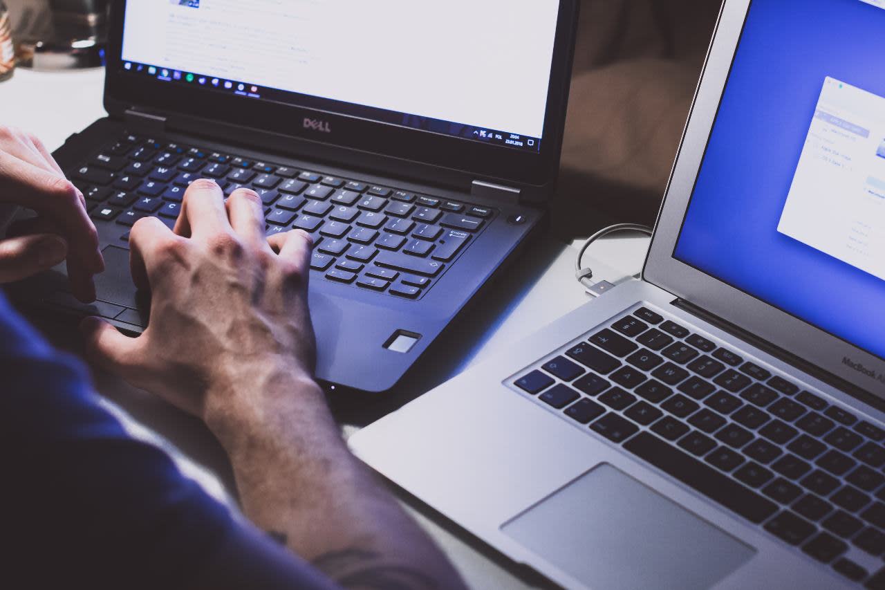A man sitting at two computers