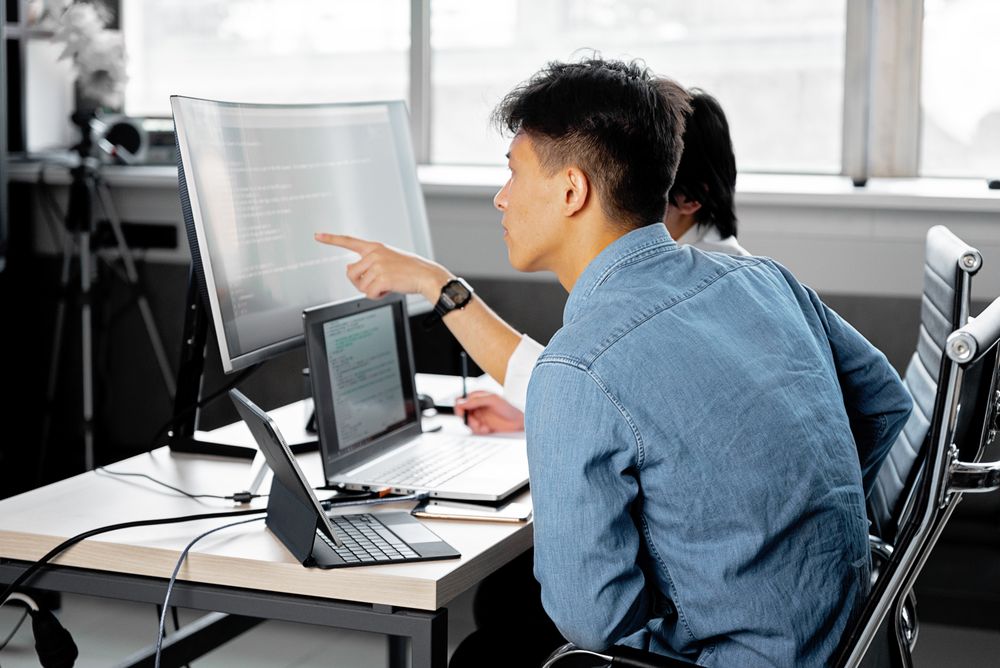 IT team members provide support to managed endpoints in an office.