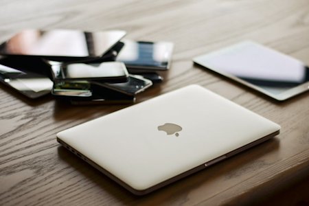 Multiple devices sitting on a desk.