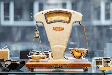 Vintage scale in a storefront window balancing two different bowls.