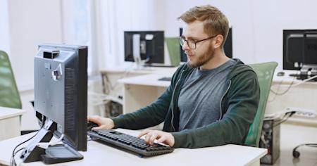 A man working at his computer in an office.