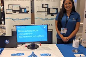 Splashtop exhibitor smiling at a conference booth with promotional materials