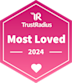 A pink hexagonal badge with the text TrustRadius Most Loved 2024 and a heart icon at the bottom.