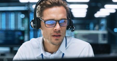 Male IT analyst examining remote desktop access on his laptop in datacenter