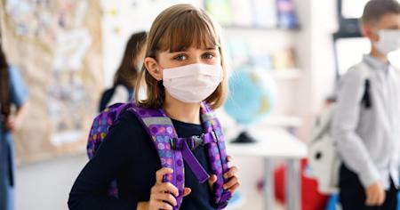 Young girl wearing a protective face mask while attending school as a precaution against Covid-19