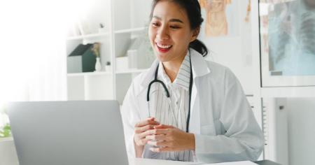 Smiling woman in healthcare industry using remote access software on a computer